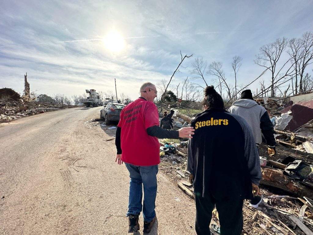 Founder of Christ In Action Free Disaster Relief group supporting a survivor